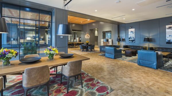 Lounge with wood floor, large rugs, comfortable seating, and eclectic decor.